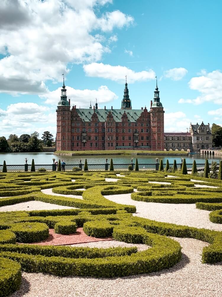 Renaissance-style Frederiksborg Castle with perfectly trimmed hedges and Castle Lake in Hillerod