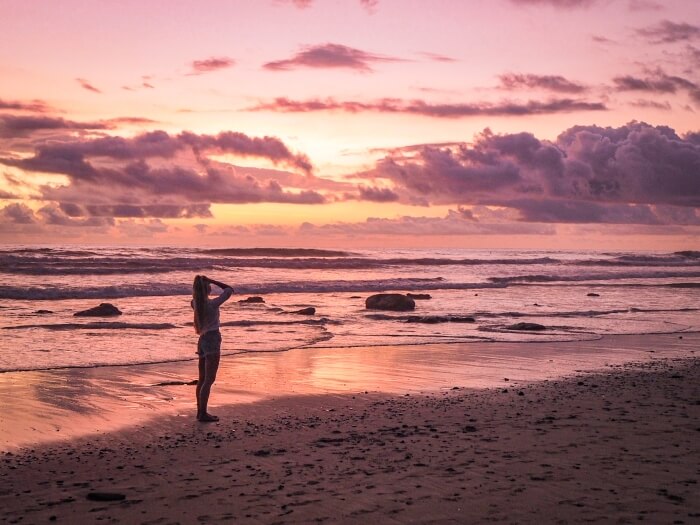 Purple clouds and pink sky during sunset at Santa Teresa beach in Costa Rica
