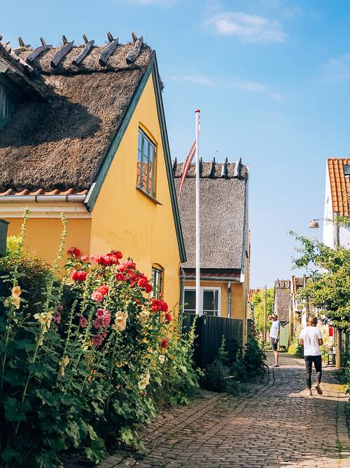 a yellow thatched-roof cottage in the historical town of Dragor in Denmark