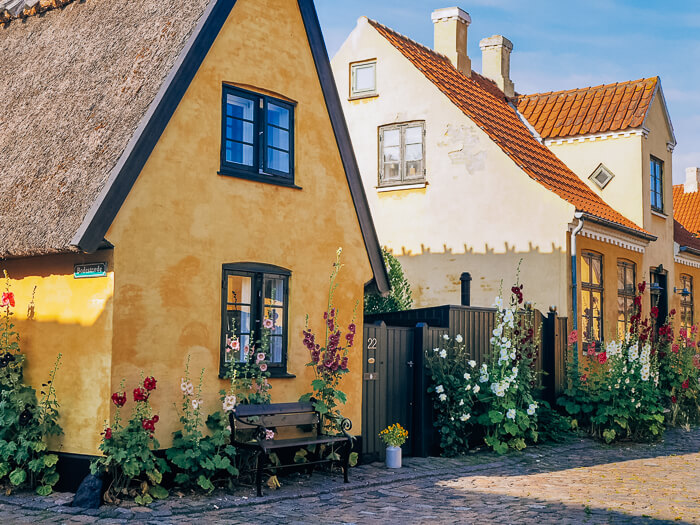 an old cobbled street and small yellow houses in Dragor, a tiny fishing village and one of the best day trips from Copenhagen