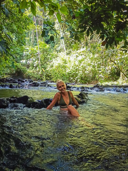 a woman sitting in the free natural hot springs of La Fortuna, one of the best places to include in your 10 day Costa Rica itinerary