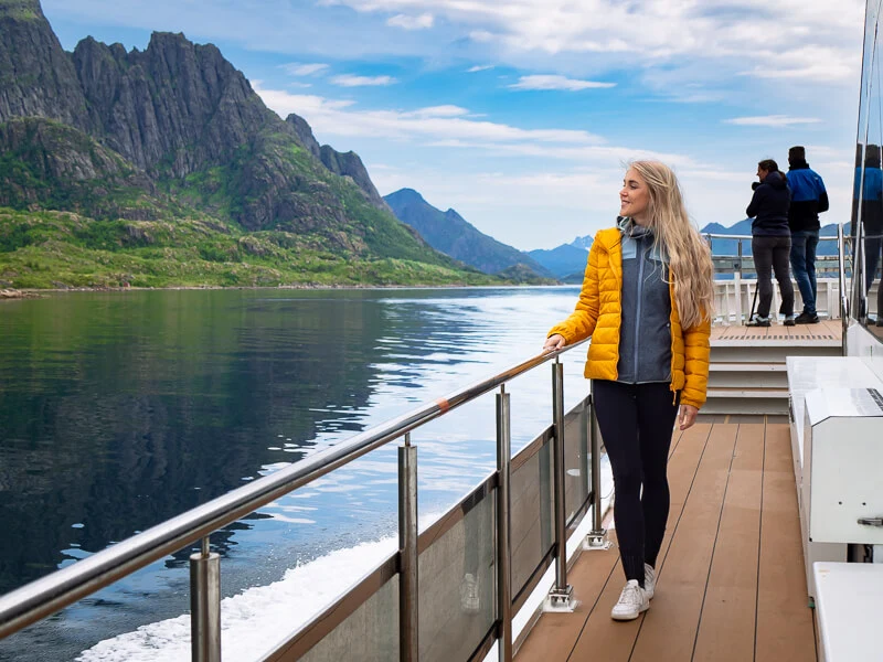 Me standing on the deck of a ship surrounded by mountainous landscapes during the Trollfjord cruise