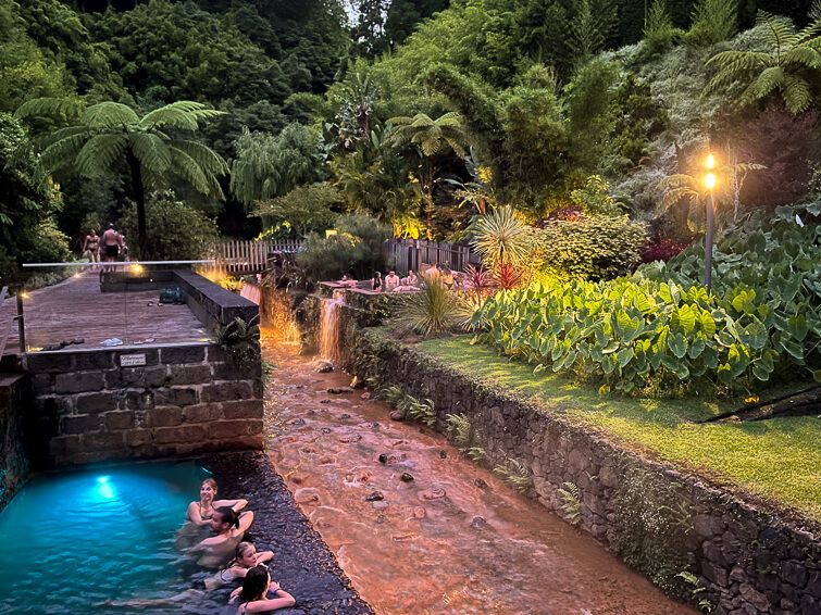 People relaxing in thermal pools surrounded by a tropical garden at Dona Beija hot springs in Furnas.