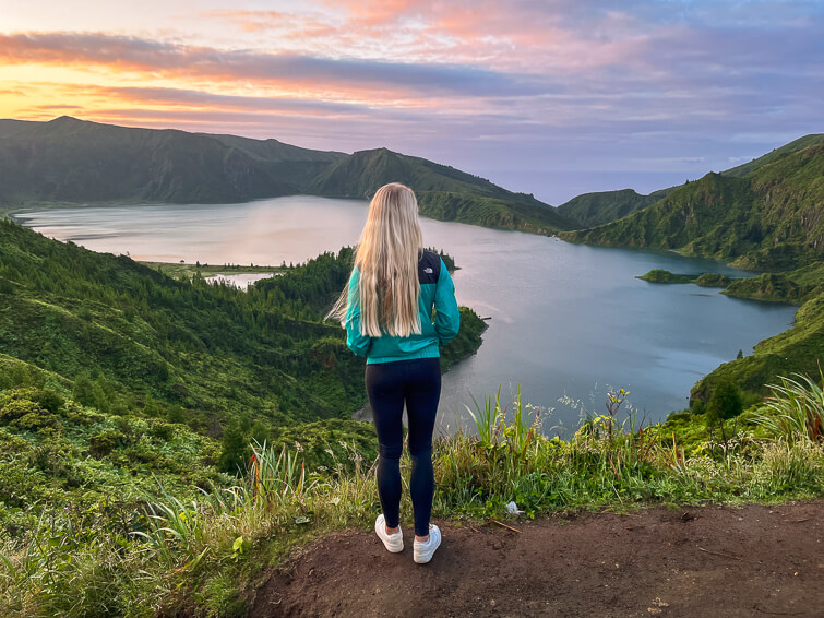 Me admiring the view over the Lagoa do Fogo lake with colorful sunrise sky in the background