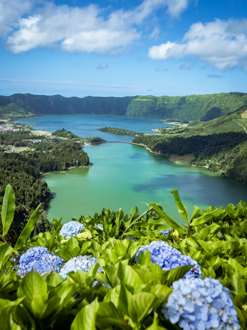 The blue-green lakes of Sete Cidades surrounded by a massive volcanic crater, viewed from Vista do Rei viewpoint, a great area for hiking in the Azores.