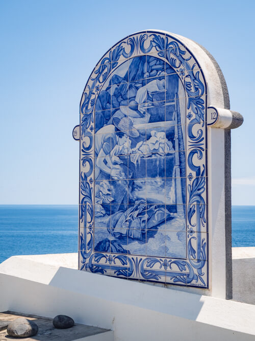 Blue and white painted Portuguese tiles depicting a group of women working.